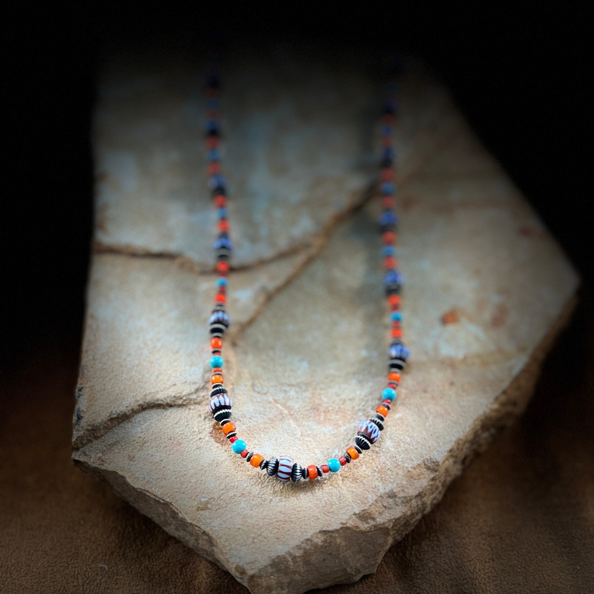 Turquoise and coral beads, complemented by sterling silver accents and artisan glass beads